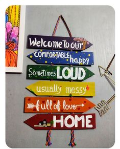 several wooden signs hanging on the wall with words written in different languages and colors, along with a key