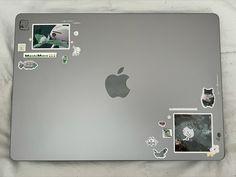 an apple laptop with many stickers on it