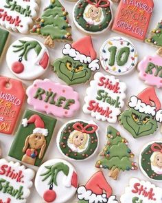 decorated christmas cookies are displayed on a white tablecloth with holiday sayings and decorations