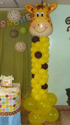 a giraffe balloon sitting on top of a table next to a birthday cake