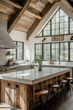 a large kitchen with an island in the middle and lots of stools around it