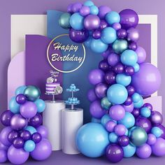 purple and blue balloons are on display in front of a happy birthday sign with cake