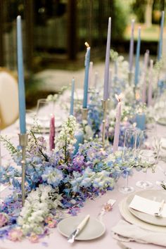 the table is set with candles, plates and napkins for an elegant wedding reception