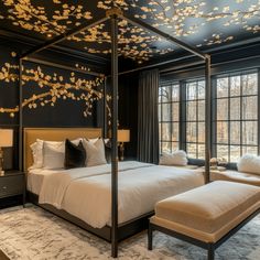 a bedroom with black walls and white bedding is decorated with gold leafy branches