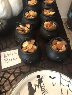 a table topped with black caulders filled with crackers