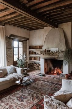 a living room with a fireplace, couches and rugs on the floor in front of it