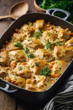 a casserole dish with chicken, carrots and parsley on the side