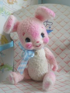 a pink and white stuffed animal sitting on top of a chair