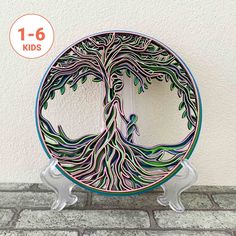 a glass plate with a tree design on the front and bottom, sitting on a brick floor