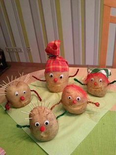 some very cute looking rocks with eyes and hair on top of a green table cloth