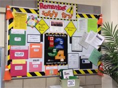 a bulletin board with construction signs and sticky notes on the front, next to a potted plant