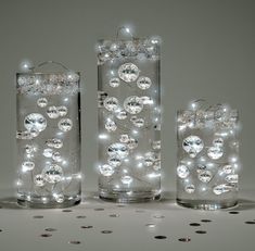 three glass vases with lights in them