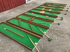 several different types of golf putts laid out on the ground in front of a red building