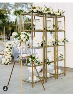 a gold shelving with white flowers and greenery