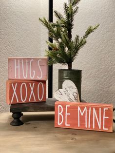 two wooden blocks with the words hugs xoxo and be mine written on them