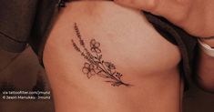 a close up of a person's stomach with flowers tattooed on the side of her body