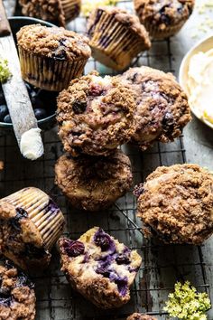 blueberry muffins on a cooling rack next to other muffins and fruit