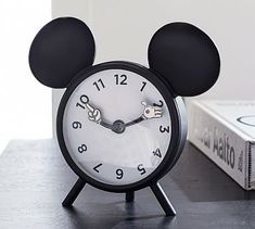 a mickey mouse alarm clock sitting on top of a table next to a box with an envelope