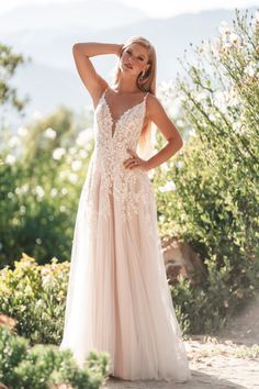 a woman in a wedding dress posing for the camera with her hand on her head