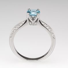 The ring is centered with one (1) round mixed cut natural aquamarine weighing 0.71 carat and set into a four-prong head. The side faces of the ring are each accented with three (3), bead set, round brilliant cut diamonds. The shank features a knife edge profile and is accented with two- rows of seven (7), bead set, round brilliant cut diamonds on each side. The ring measures 6.3mm at the top, rises 7.2mm above the finger, tapering to 2.8mm wide and 1.5mm thick at the base of the shank. We offer Aquamarine Engagement Ring, Bead Set, Natural Aquamarine, June Birth Stone, Brilliant Diamond, One 1, Round Brilliant Cut Diamond, High Quality Jewelry, Round Brilliant Cut