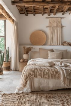 a large bed sitting in a bedroom next to a window with wooden beams on the ceiling