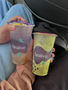 two people holding plastic cups with tealive on them