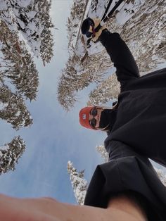 a person standing in the snow with skis on their feet and trees behind them