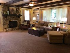 a living room filled with furniture and a fire place in the middle of a room