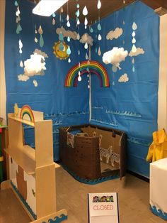 an indoor play area for children with cardboard boxes and paper clouds hanging from the ceiling