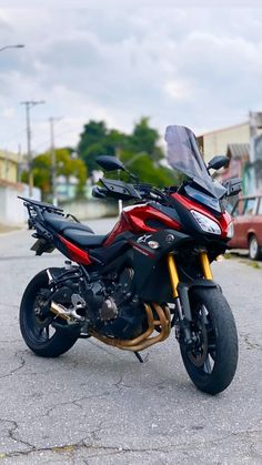 a red and black motorcycle parked on the street