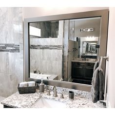 a bathroom with marble counter tops and a large mirror