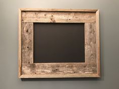 a wooden frame hanging on the wall with a chalkboard in it's center