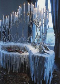 there are many candles that have been made out of ice and icicles on the table