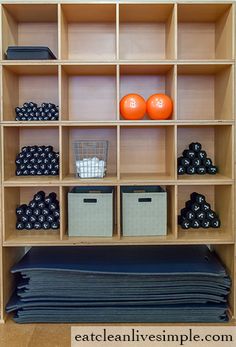 an organized closet with folded clothes and storage bins on the bottom shelf in front of it