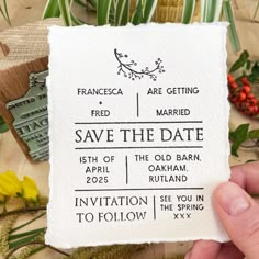 a person holding up a paper save the date card