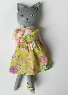 a gray cat wearing a yellow dress with flowers on it's chest and head