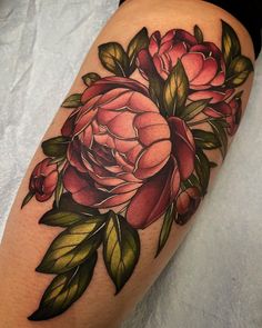 a close up of a flower on a person's leg, with leaves and flowers around it