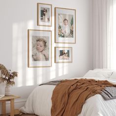 a bedroom with white walls and pictures on the wall above the bed in front of it