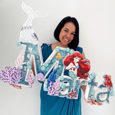 a woman holding up some cut out letters