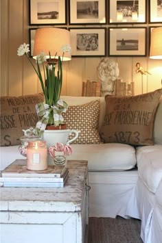 a living room filled with lots of furniture and pictures on the wall above it's coffee table