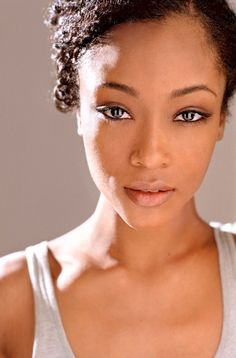 a close up of a person wearing a tank top and looking at the camera with a serious look on her face