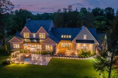 an aerial view of a house at night with lights on the front and side windows