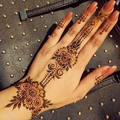 a woman's hand with henna tattoos on it