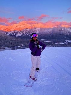 a person on skis standing in the snow with mountains in the backgroud