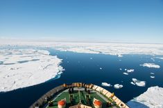 the bow of a ship in the ocean with ice floes and water behind it