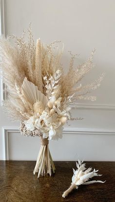 an arrangement of dried flowers in a vase on a table