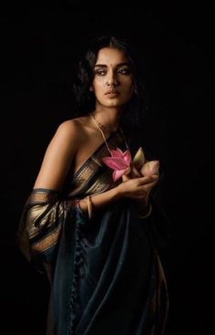 a woman in a sari holding a flower