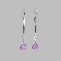 Add a touch of color and sparkle with our hand hammered twig earrings! Each earring showcases a uniquely textured sterling silver twig that dangles gracefully from a french-hook ear wire catching the light with every movement. A delicate gemstone drop at the base adds a vibrant pop of color and a hint of elegance. Faceted amethyst gemstone drop Hammered sterling silver twig Sterling silver french-hook ear wires 1.5" in length Recycled metal and responsibly sourced stones Embrace the beauty of ha Sterling Wire Gemstone Bead Drop Earrings, Twig Earrings, Trio Ring, Simple Band, Sapphire Solitaire, Hammered Sterling Silver, Handmade Rings, Design Jewelry, Recycled Metal