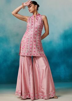 Featuring a pink silk sleeveless kurta with band collar neckline, embellished with gota, zari and mirror applique work. Paired with an embellished garara bottoms and a matching organza dupatta with cutwork border detailing and tassels on hem. An absolute fusion silhouette for Sangeet and Engagement parties. Composition : Kurta & Garara: Slub Silk, Dupatta: Organza Care: Dry Clean Only and Vacuum Storage All products can be customised for sleeves, length of blouse and neck design Delivery : 6-8 weeks as the product is hand crafted. Check Size Guide or choose MySize for free customisation (All Sizes above XL can be made at 15% additional cost) For more information and sizes please contact fabiliciousfashion@gmail.com or visit our Copenhagen studio. Sleeveless Kurta, Pink Kurta, Applique Work, Vacuum Storage, Organza Dupatta, Silk Dupatta, Band Collar, Kurta Set, Cut Work