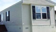 a white mobile home sitting in front of a house